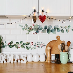 Green eucalyptus and red berry vine wall stickers on a white kitchen tile background