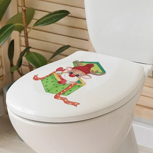 Detailed view of festive Christmas reindeer sticker on white toilet lid in warm bathroom