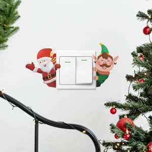 Détail des stickers de Noël Père Noël et Elfe autour d'un interrupteur mural blanc