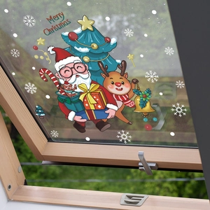 Détail de stickers de Noël avec Père Noël, élan et flocons sur vitre de fenêtre