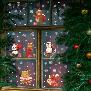 Weihnachtliche Fensteraufkleber mit Zeichentricktieren und Schneeflocken auf Holzfenstern