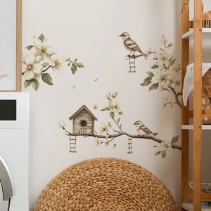 Detail of vintage wall sticker with magnolia branches, birds, and wooden birdhouse