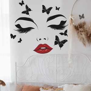 Minimalist wall decal featuring long eyelashes, red lips, and black butterflies on a white wall