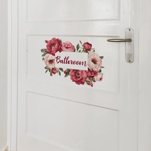 Close-up of floral bathroom wall decal with pink peonies and cursive script on white door