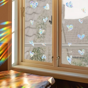 Rainbow prism window film with irregular heart shape creating colorful light on a wooden table