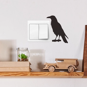 Künstlerisches schwarzes Vogel-Wandtattoo über einem Holzregal in gemütlichem Zuhause