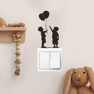 Detail showing black silhouette wall sticker of children and balloons on a light switch panel