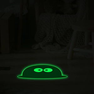 Detail of glow in the dark green cartoon monster floor sticker with big eyes