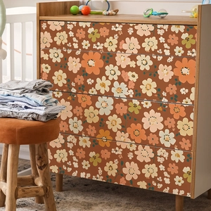 Bohemian floral self-adhesive wallpaper with retro daisies on a white chest of drawers
