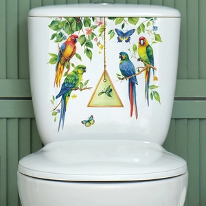 Close-up of tropical parrot and green leaves wall decals on a white bathroom toilet tank