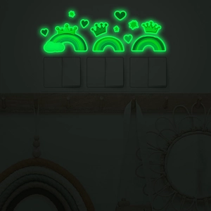 Luminous rainbow heart and crown wall stickers glowing green in a dark bedroom
