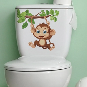Detailed view of cartoon monkey waterproof sticker on a white ceramic toilet tank surface
