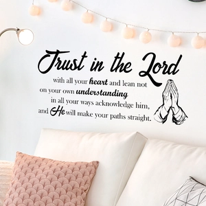 Bible verse wall decal with praying hands over sofa in a cozy living room decor