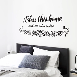 Bless this home and all who enter black wall decal with floral vine patterns above bed