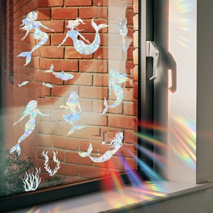 Rainbow prism mermaid window decals creating colorful reflections on brick wall surface