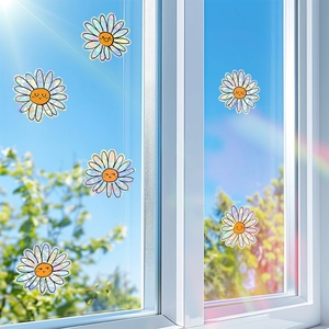 Holographic daisy flower suncatchers on a glass window creating rainbow prism effects