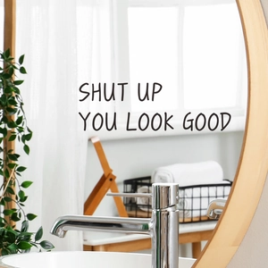Black 'SHUT UP YOU LOOK GOOD' vinyl wall decal sticker on a round wooden frame mirror