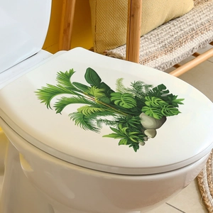 Detail of tropical monstera leaf wall stickers applied on a white toilet lid surface