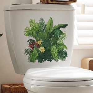 Macro shot of tropical monstera and palm leaf decals on a white ceramic toilet tank