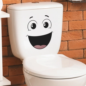 Funny smiling face wall sticker on a white toilet tank with a rustic brick background