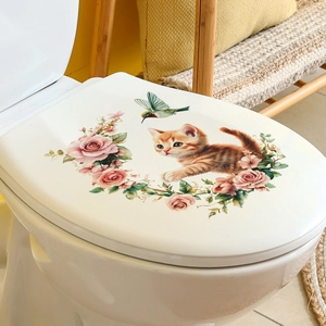 Détail d'un chat orange et colibri avec autocollants de roses roses sur abattant de WC