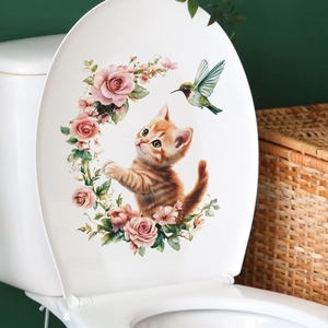 Détail de l'autocollant chat et fleurs roses sur un abattant de WC blanc pour la décoration