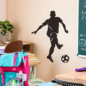 Black silhouette wall decal of a soccer player dribbling with a ball for home decor