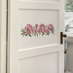 Sticker mural floral avec pivoines roses et texte welcome sur une porte de chambre