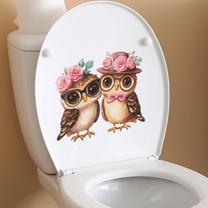 Cartoon couple owls with pink roses decorative sticker on a white toilet lid in a bathroom