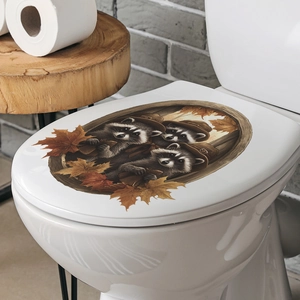 Close-up of cute raccoon and autumn maple leaves sticker on a white toilet lid