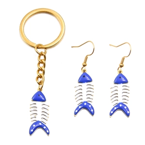 Detailweergave van de visgraat sieradenset met sleutelhanger en oorbellen van goud emaille