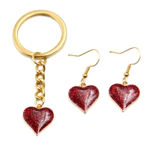 Dettaglio del portachiavi a cuore glitter rosso e orecchini abbinati in oro KC