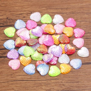 Macro view of colorful heart-shaped resin charms with fish scale texture and iridescent finish