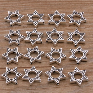 Macro shot of 16 antique silver hexagram spacer beads with textured finish for DIY jewelry