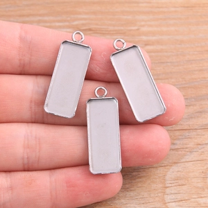 Close-up of rectangular stainless steel bezel trays held by hand for DIY jewelry sizing
