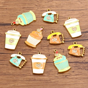 Colorful enamel ice cream, cup, and phone pendants with rhinestones on wood background