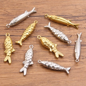 Set aus 304 Edelstahl Meeresfisch-Anhängern in Gold und Silber auf Holzgrund