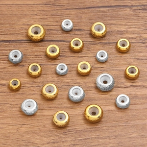 Polierte Edelstahl Schiebeperlen in Gold und Silber mit Silikonkern auf Holz