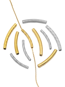 Detail of embossed curved tube beads in gold and silver finish for DIY jewelry making
