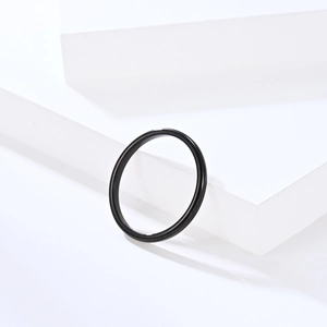 Detailed macro view of minimalist black tungsten steel ring with a polished mirror finish