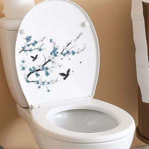 Blue cherry blossom and bird branch decal applied on a white toilet lid for bathroom decor