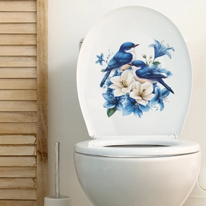 Détail d'autocollant floral d'oiseau bleu et de fleurs sur un abattant de WC blanc