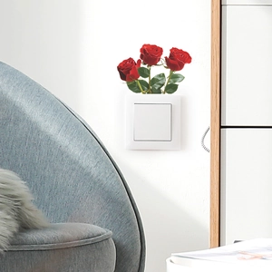 Detail eines kreativen Wandschalter-Aufklebers mit roten Rosen auf weißer Abdeckung