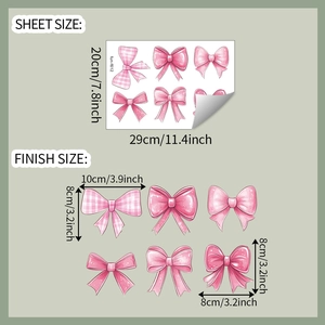 Close-up of cartoon pink bow wall stickers with size labels in centimeters and inches