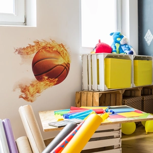 Sticker mural de basket en flammes dynamique posé sur un mur blanc de chambre d'enfant