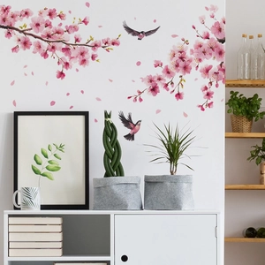 Detail view of pink cherry blossom and bird wall decals in a modern living room setting