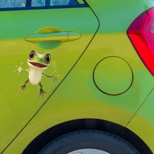 Close-up of a 3D funny big-eyed green frog car window sticker on a bright green vehicle door