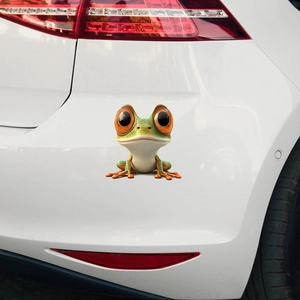 Detailed 3D funny green frog car sticker with big orange eyes on a white vehicle bumper