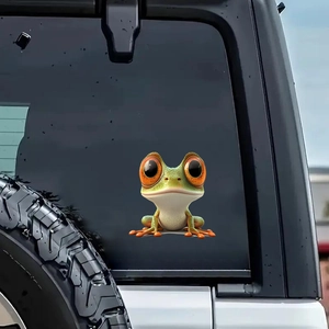3D cartoon tree frog car window sticker with large orange eyes on black vehicle exterior
