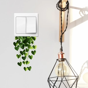 Green vine leaf wall stickers for light switch decoration in a minimalist home
